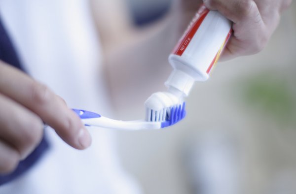 Man Putting Toothpaste on Toothbrush